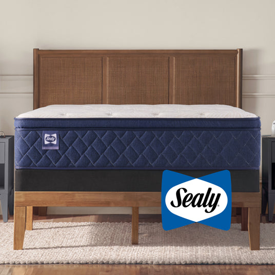 Blue mattress on a wooden bed frame with Sealy logo