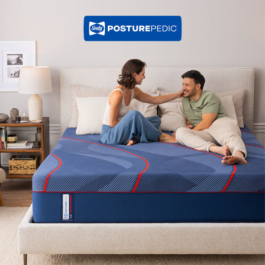 Couple enjoying a Sealy Posturepedic mattress in a bedroom