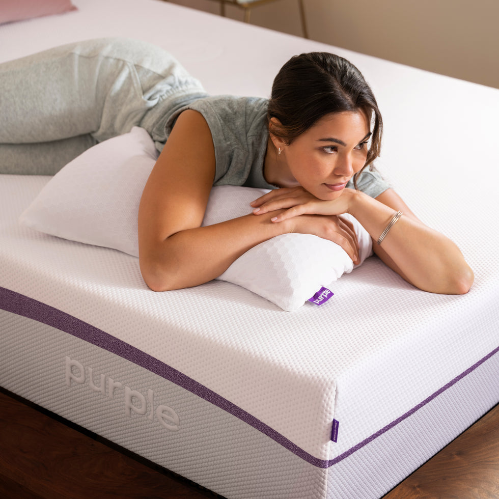 Woman laying on Purple mattress and pillow