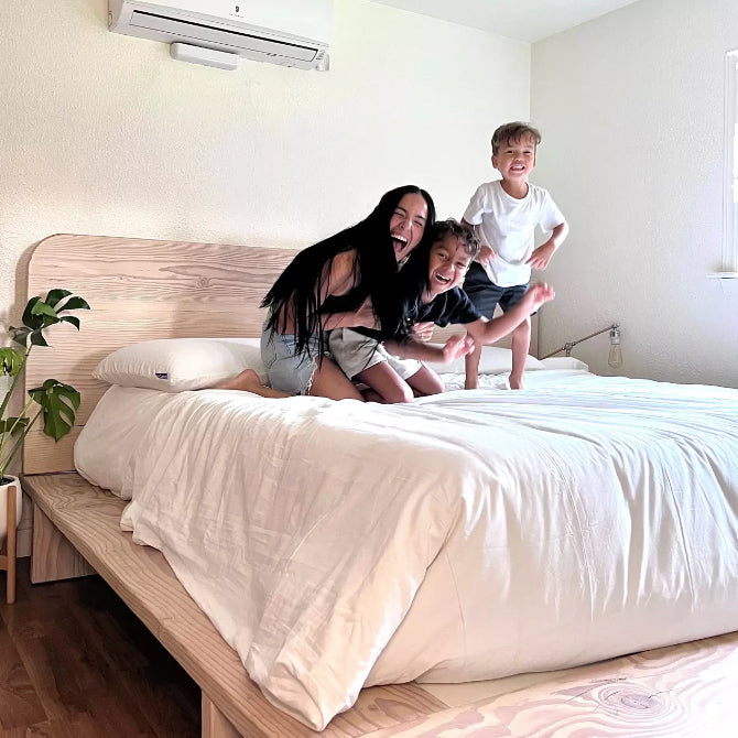 Family jumping on Purple bed