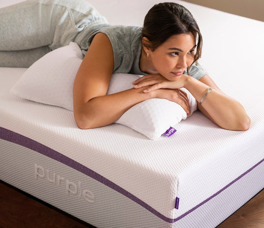 Women laying on a Purple pillow and mattress