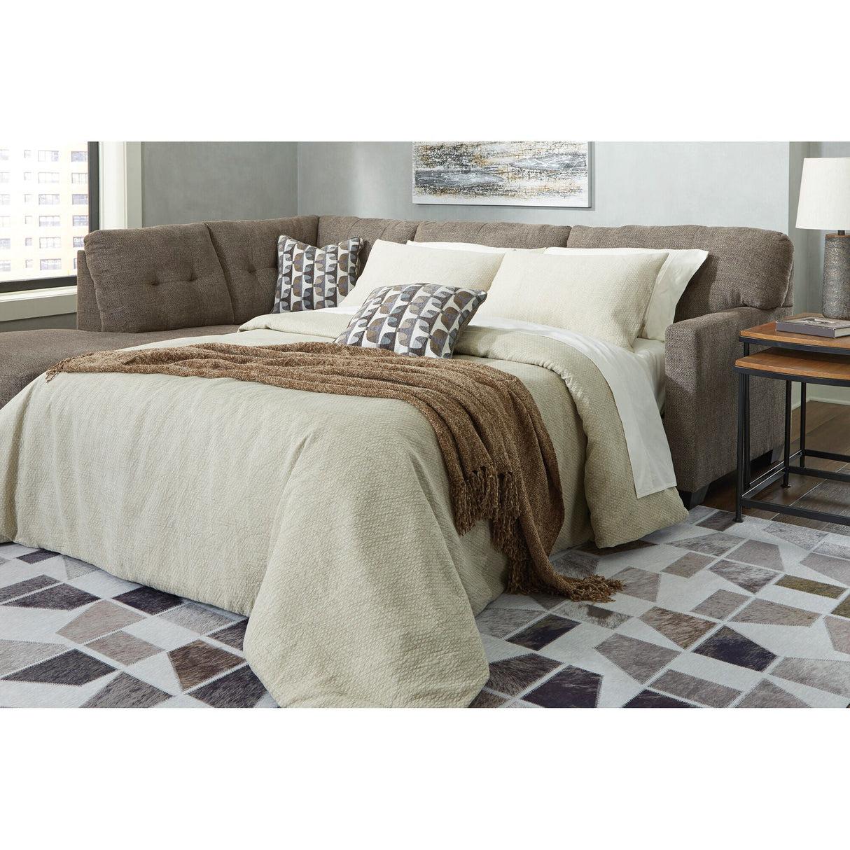 A room setting featuring Mahoney Chocolate Left Chaise Full Sleeper Sectional