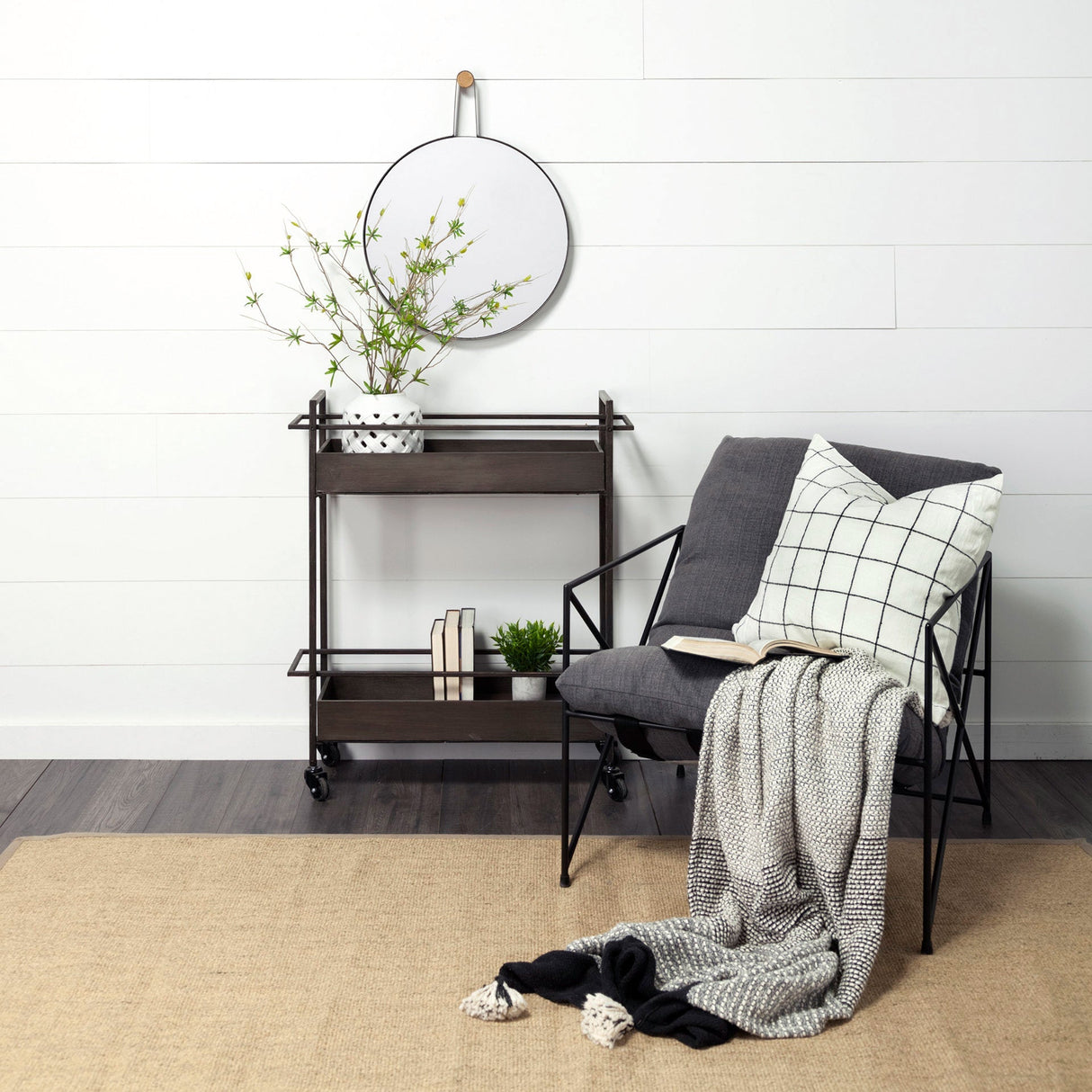 A room setting featuring Collie Black Round Wall Mirror