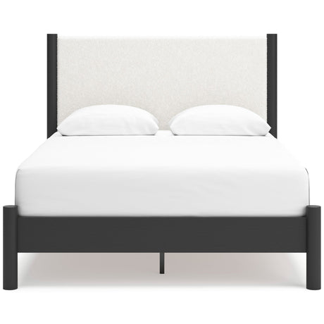 A beige upholstered panel bed with a wooden frame and a headboard, pictured in a clean, empty room.