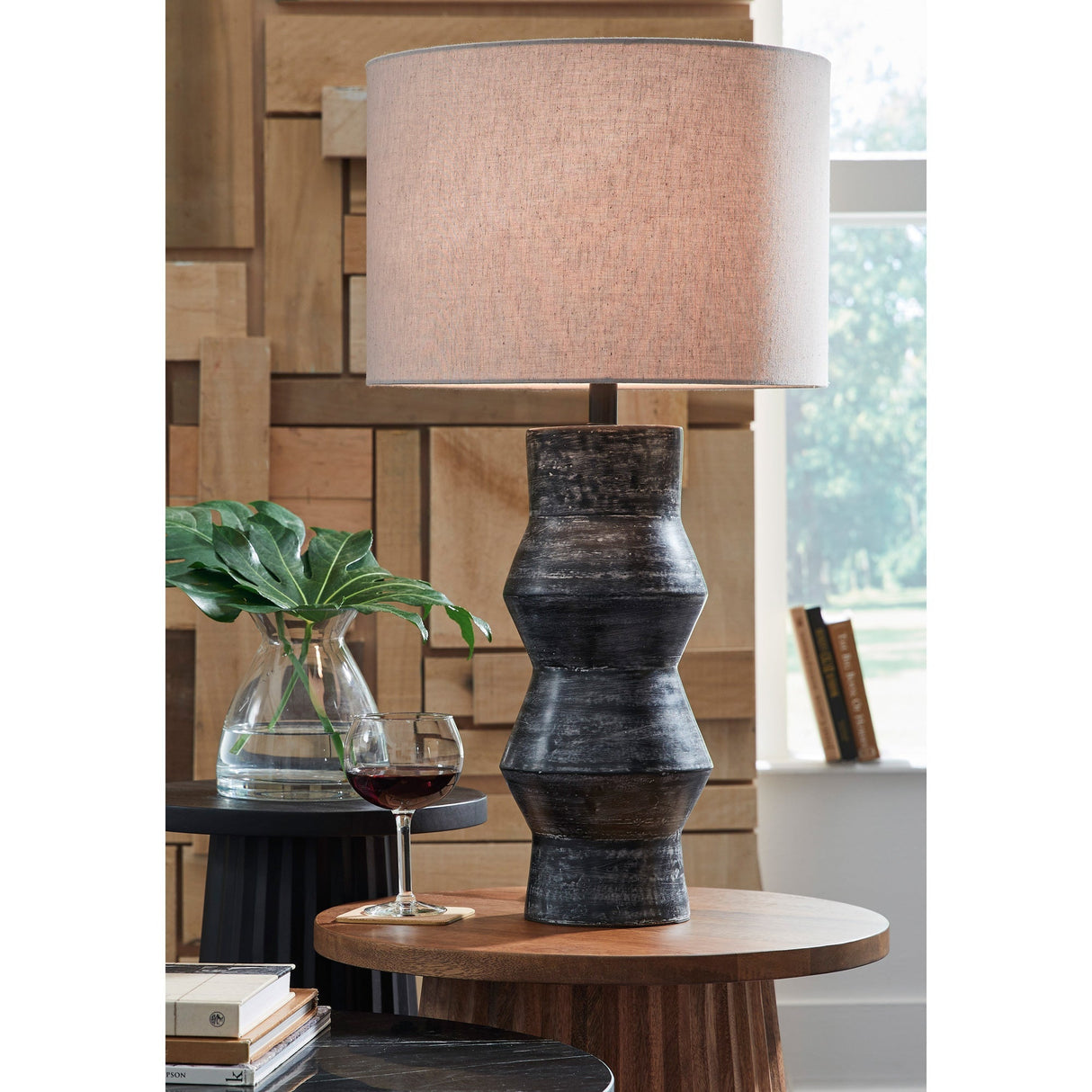 A room setting featuring Kerbert Distressed Black Table Lamp