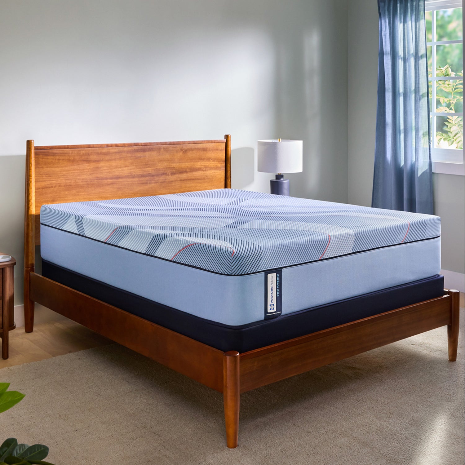 Blue mattress on a wooden bed frame in a bedroom setting.