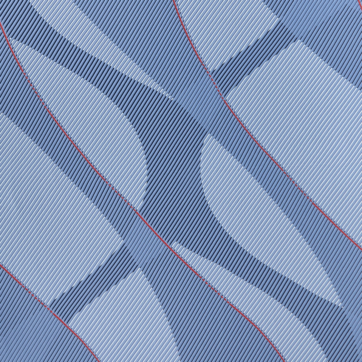 Close-up of a textured blue fabric with red stitching