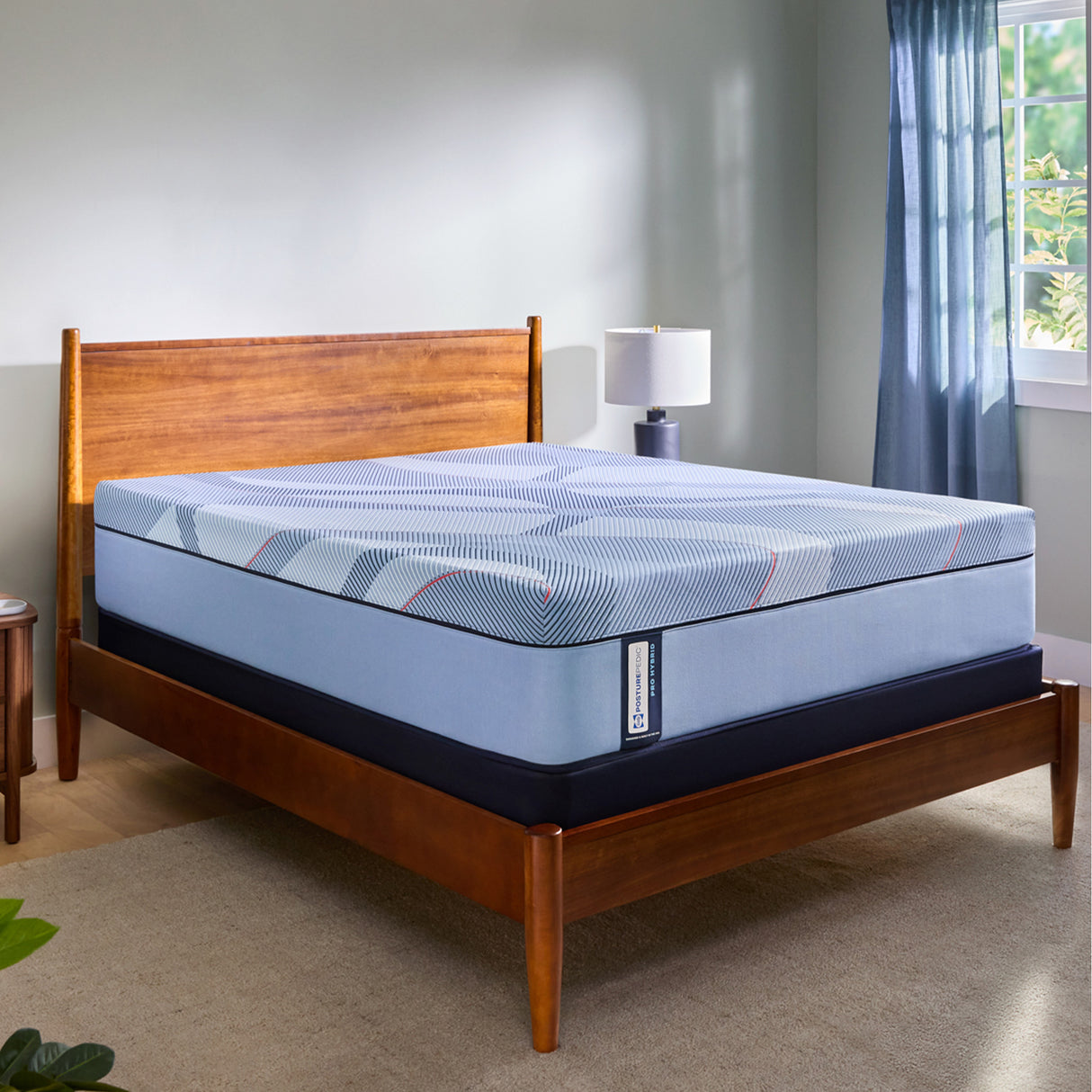 Blue mattress on a wooden bed frame in a bedroom setting