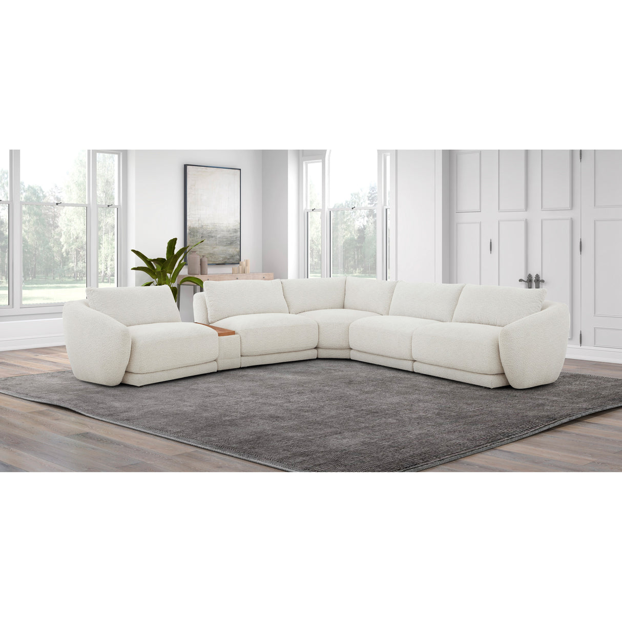 White sectional sofa in a modern living room with large windows and a gray rug.