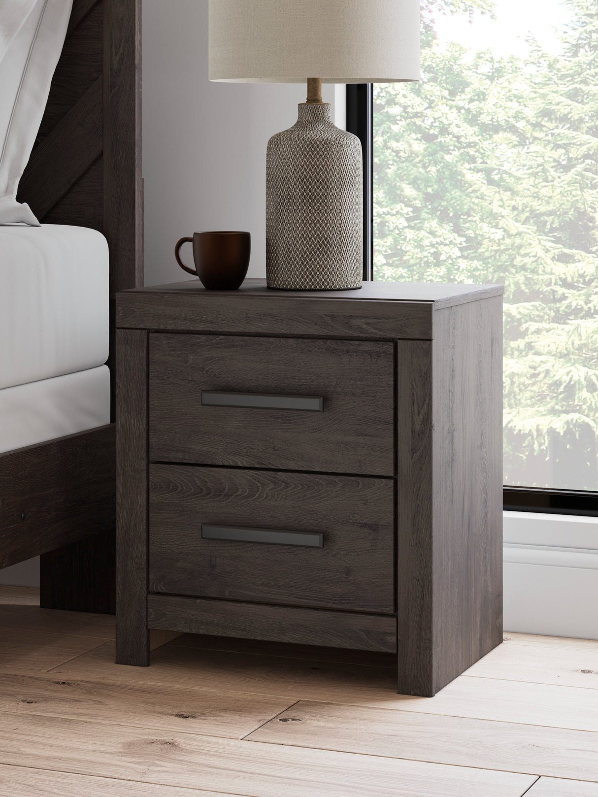 A room setting featuring Prendonea Charcoal Nightstand