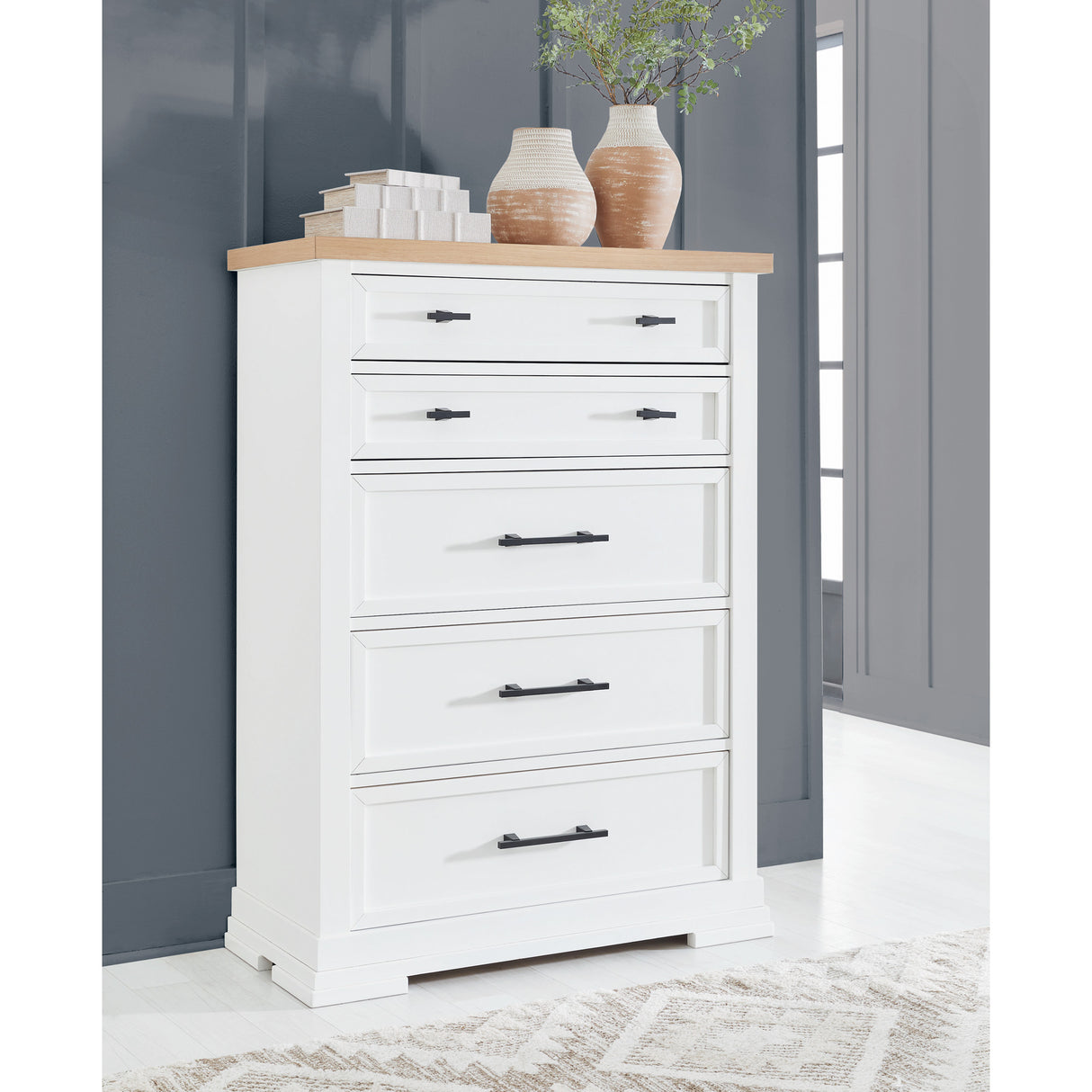 A room setting featuring Ashbryn White 5 Drawer Chest