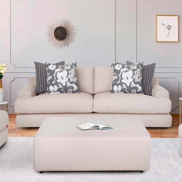 Beige sofa with floral-patterned cushions in a living room setting.