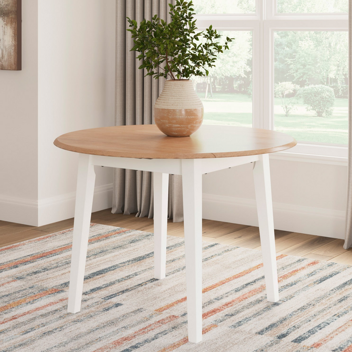 Round wooden table with white legs in a room with a striped rug and large window.