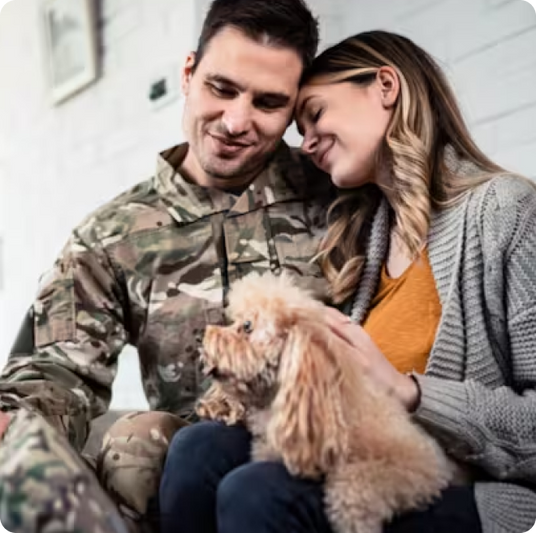Military veteran and woman smiling together with dog