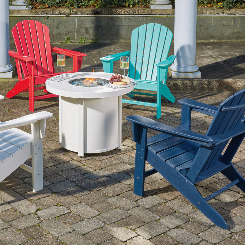 Colorful Adirondack chairs around a fire pit table on a patio.