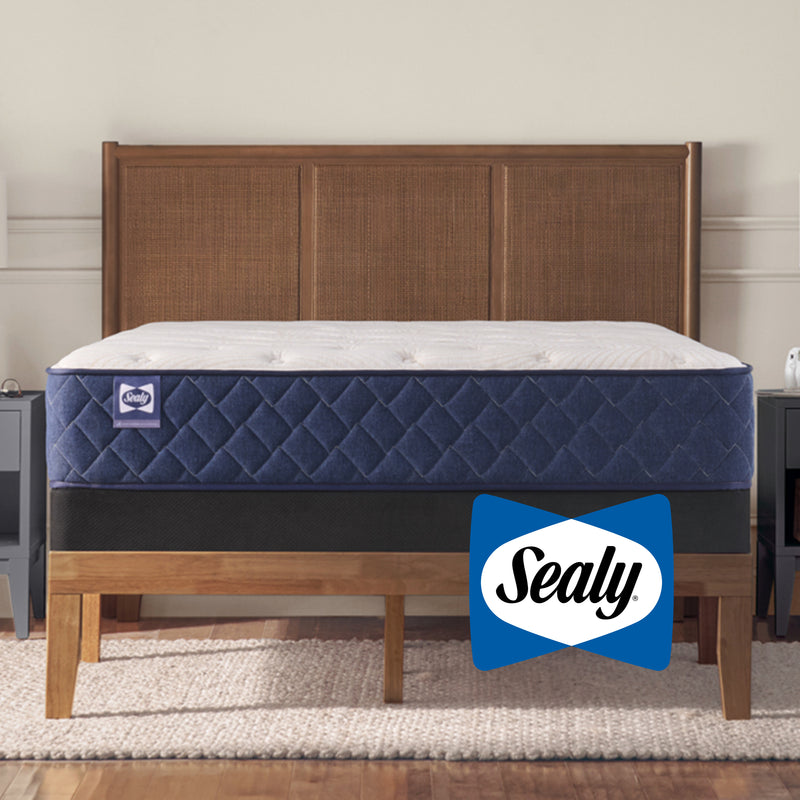 Blue mattress on a wooden bed frame with Sealy logo in a bedroom setting