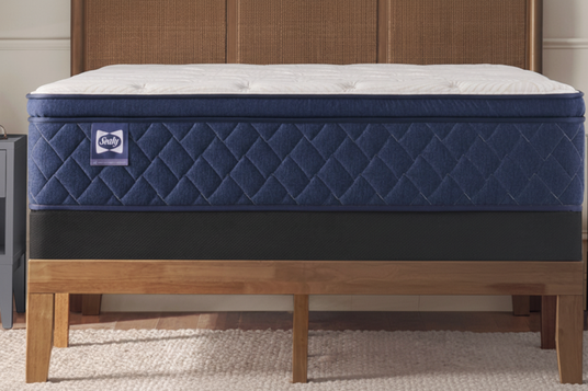 Blue mattress on a wooden bed frame in a room setting.