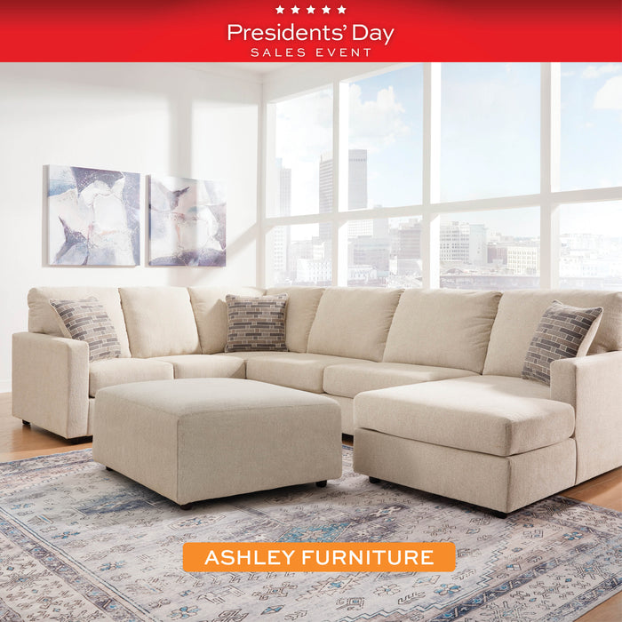 Beige sectional sofa with ottoman in a living room setting, Ashley Furniture advertisement.