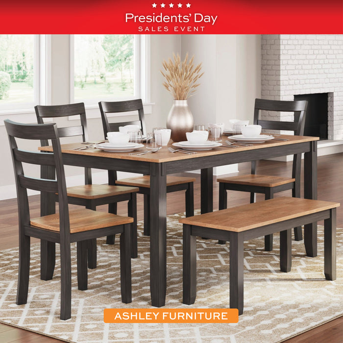 Dining room set with table, chairs, and bench in a home setting, featuring Ashley Furniture branding.