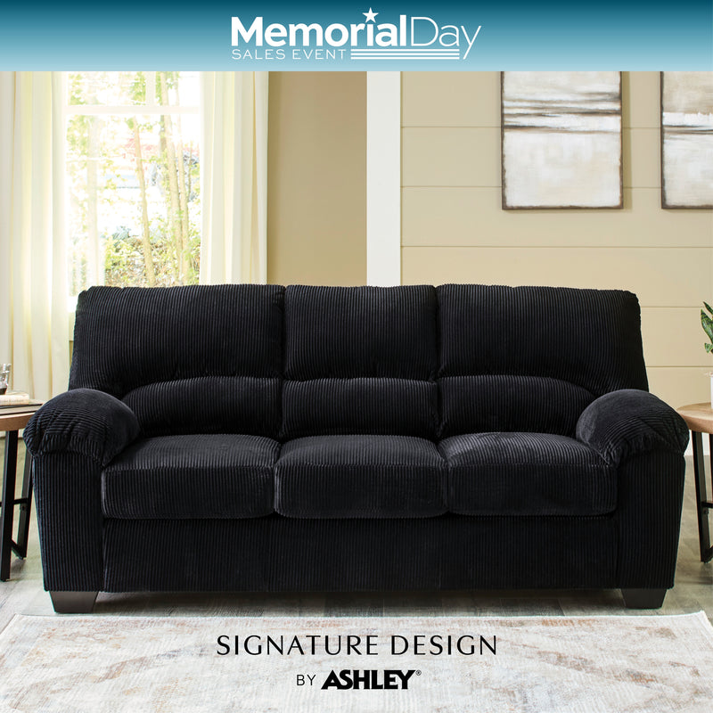 Black sofa in a living room setting with 'Memorial Day Sales Event' and 'Signature Design by Ashley' branding.