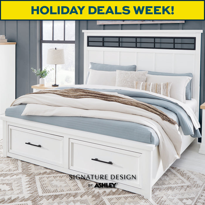 White bedroom set with bedding and lamps, featuring 'Signature Design by Ashley' branding and 'Holiday Deals Week!' text.