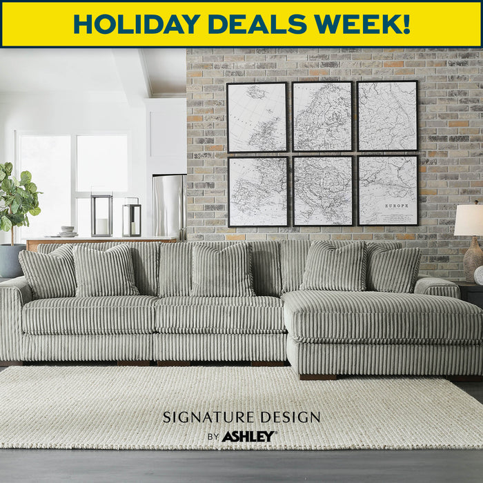 Living room with a gray sectional sofa, decorative rug, and wall art. 'Holiday Deals Week!' and 'Signature Design by Ashley' text overlay.