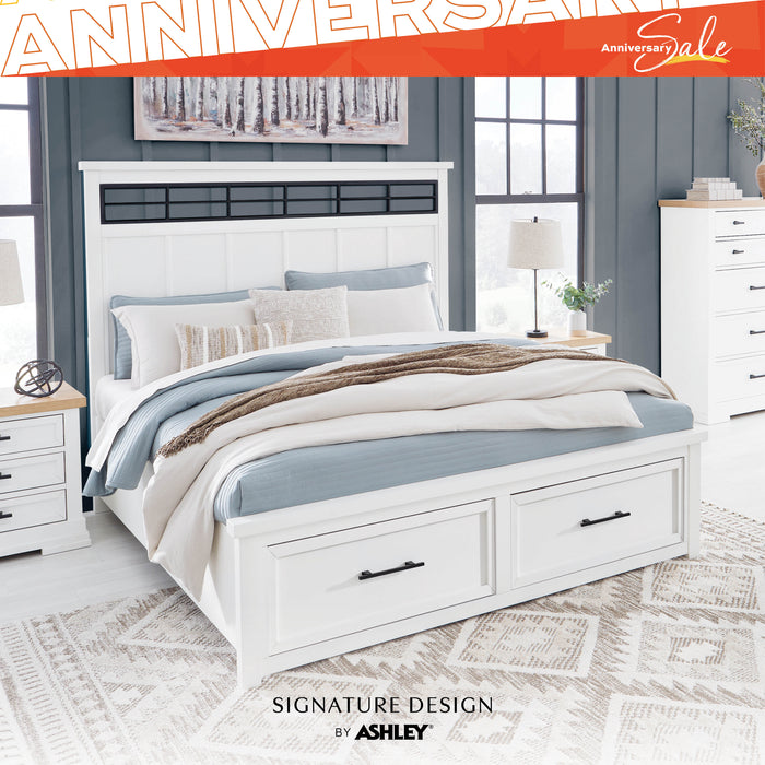 White bedroom set with storage bed, nightstands, and dresser in a room setting. 'Signature Design by Ashley' branding visible.
