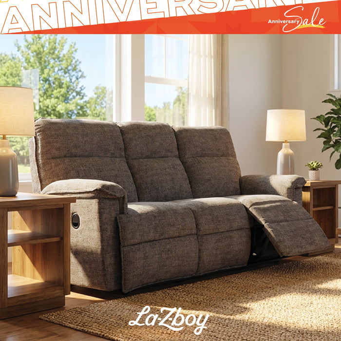 Gray reclining sofa in a living room setting with 'La-Z-Boy' branding and 'Anniversary Sale' text.