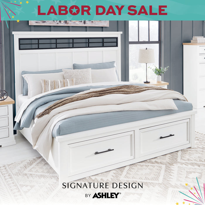 White bedroom set with bedding and drawers, featuring Ashley Furniture branding and Labor Day sale text.