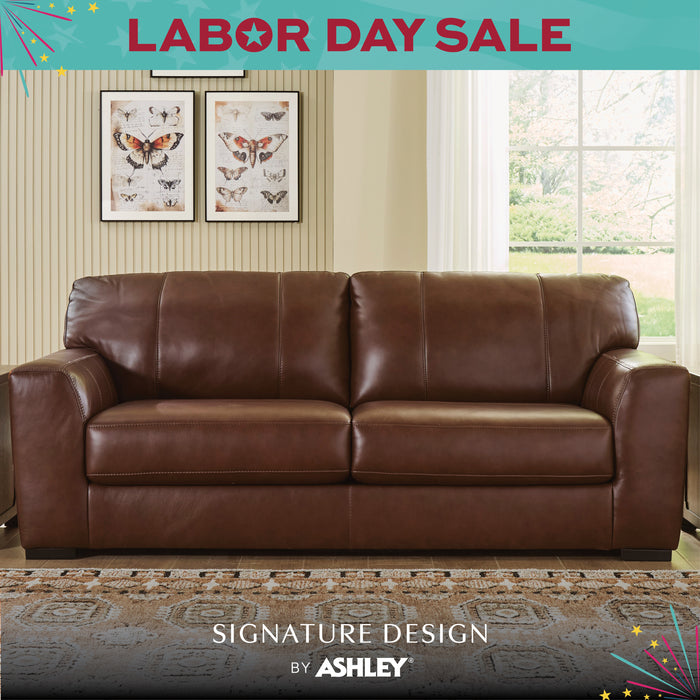 Brown leather sofa in a room with butterfly artwork and a Labor Day sale banner.