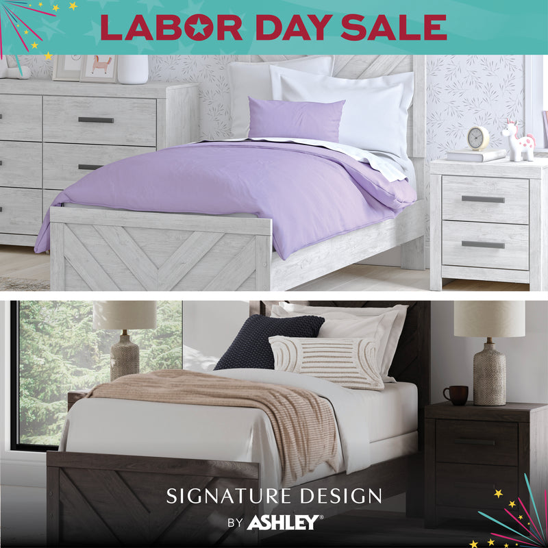 Bedroom furniture with purple bedding and 'Signature Design by Ashley' branding.
