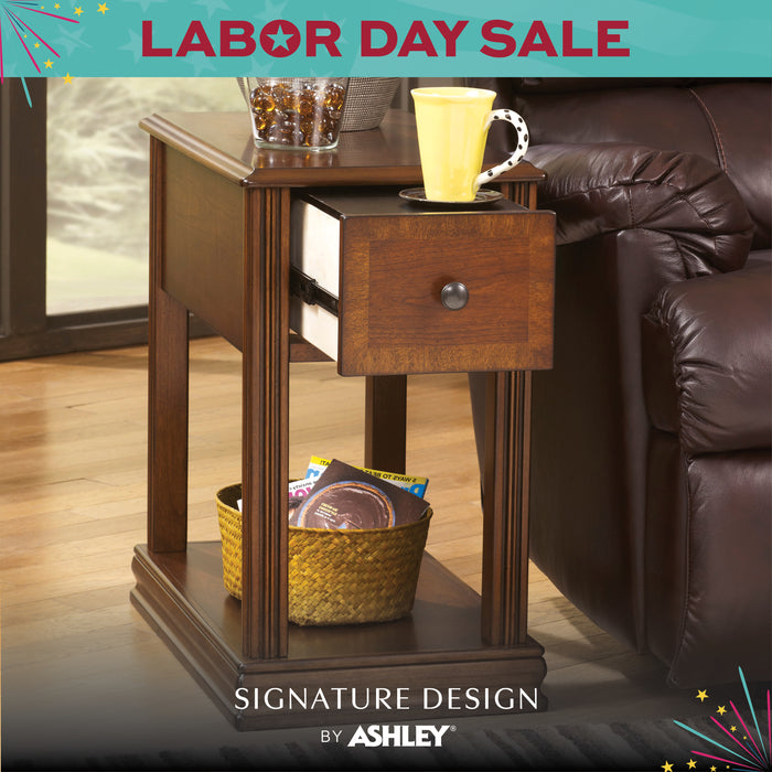 Wooden side table with a cup and snacks next to a brown leather sofa, with 'Labor Day Sale' and 'Signature Design by Ashley' text.