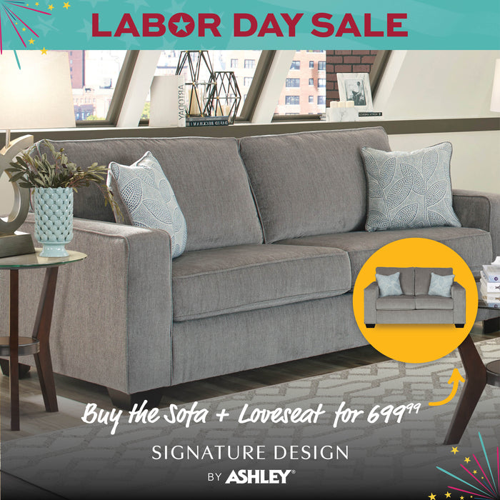 Gray sofa in a living room with 'Labor Day Sale' and 'Signature Design by Ashley' text.