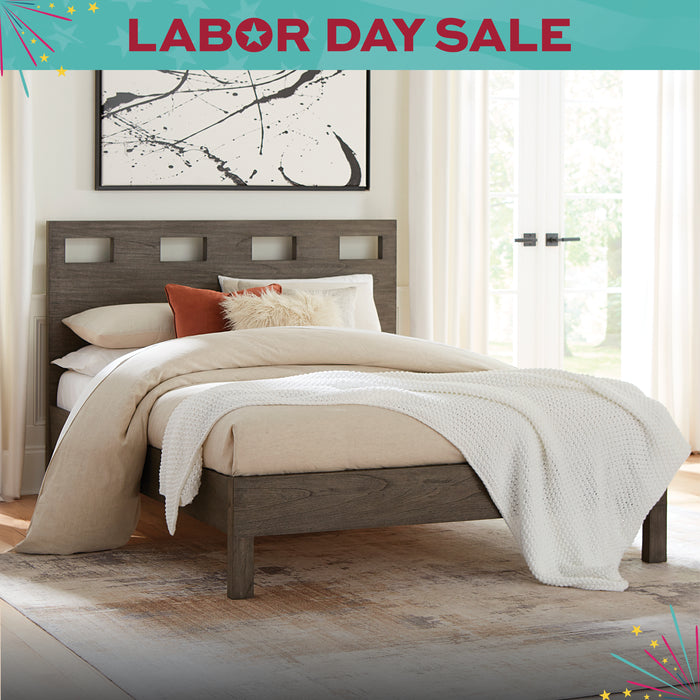 Bedroom with wooden bed and decorative pillows, featuring a 'Labor Day Sale' banner.