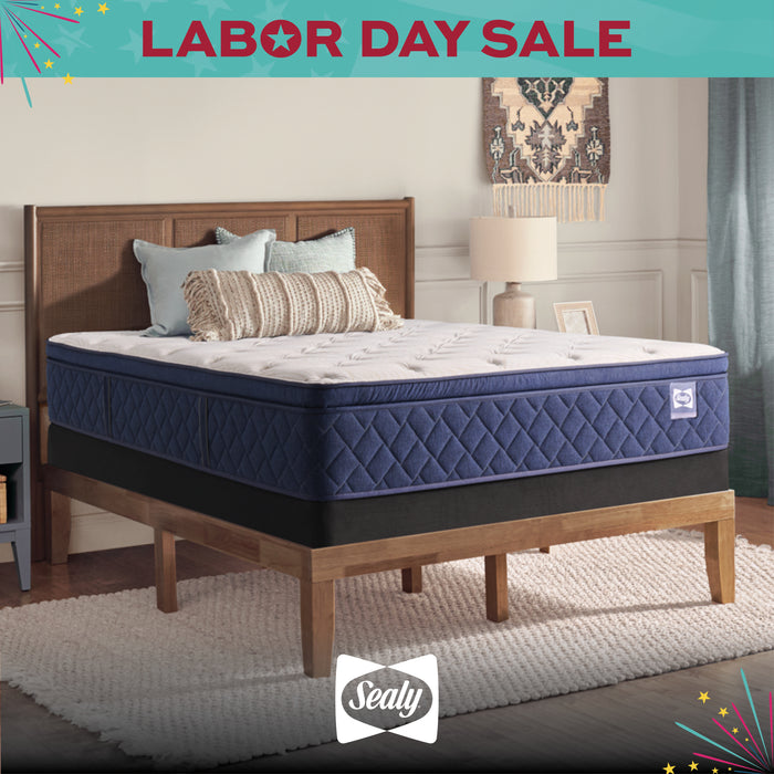 Blue mattress on a wooden bed frame with 'Sealy' branding and Labor Day sale text.