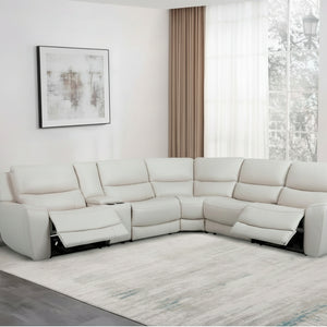 White sectional sofa in a living room with large windows and decor.