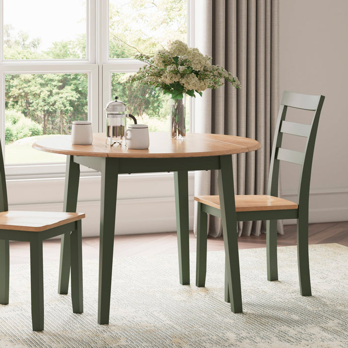 Dining table with chairs in a room with large windows and curtains.