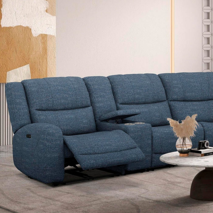Blue sectional sofa in a modern living room setting with a coffee table and decorative items.