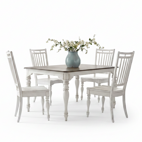 A white distressed dining set featuring a square table with a dark wood top and four matching high-back chairs, styled with a light blue vase of white flowers on a clean white background.