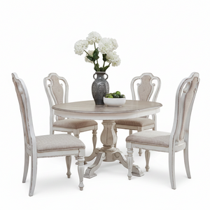 A 5-piece round dining table set with four distressed white chairs upholstered in beige fabric, featuring a matching pedestal table and a gray ceramic vase with white flowers on a clean white background.