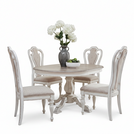 A 5-piece round dining table set with four distressed white chairs upholstered in beige fabric, featuring a matching pedestal table and a gray ceramic vase with white flowers on a clean white background.