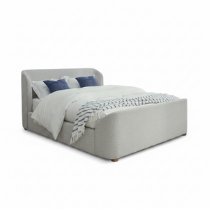 A modern upholstered bed with a textured light gray fabric, styled with white bedding, two blue accent pillows, and a blue-and-white patterned throw blanket, set against a plain white background.
