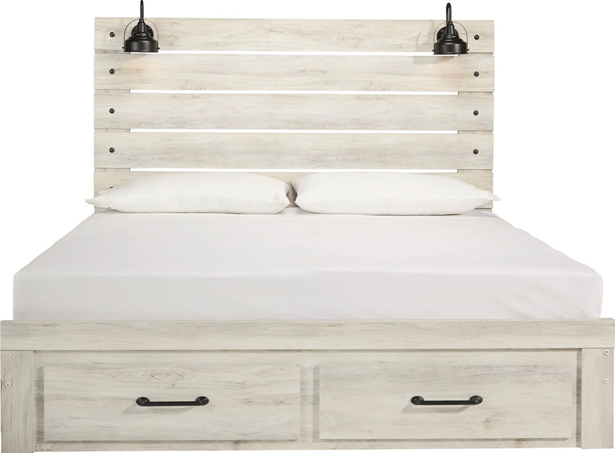 A light whitewashed wood bed frame with a slatted headboard, two built-in black wall-mounted lamps, white bedding, and two storage drawers with black handles at the bottom.