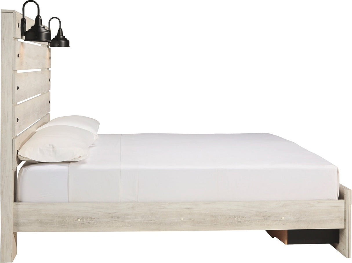 A light whitewashed wood platform bed frame with a slatted headboard, styled with white bedding and two black industrial wall sconces, shown against a solid white background.