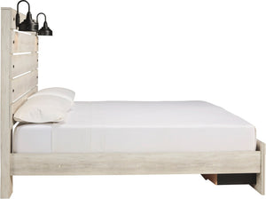 A light whitewashed wood platform bed frame with a slatted headboard, styled with white bedding and two black industrial wall sconces, shown against a solid white background.