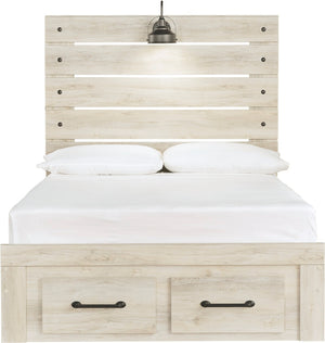 A light natural wood platform bed frame with a tall slatted headboard and two storage drawers with black handles at the bottom. The bed is dressed in white bedding and two white pillows, with a small black hanging lamp mounted above the headboard.
