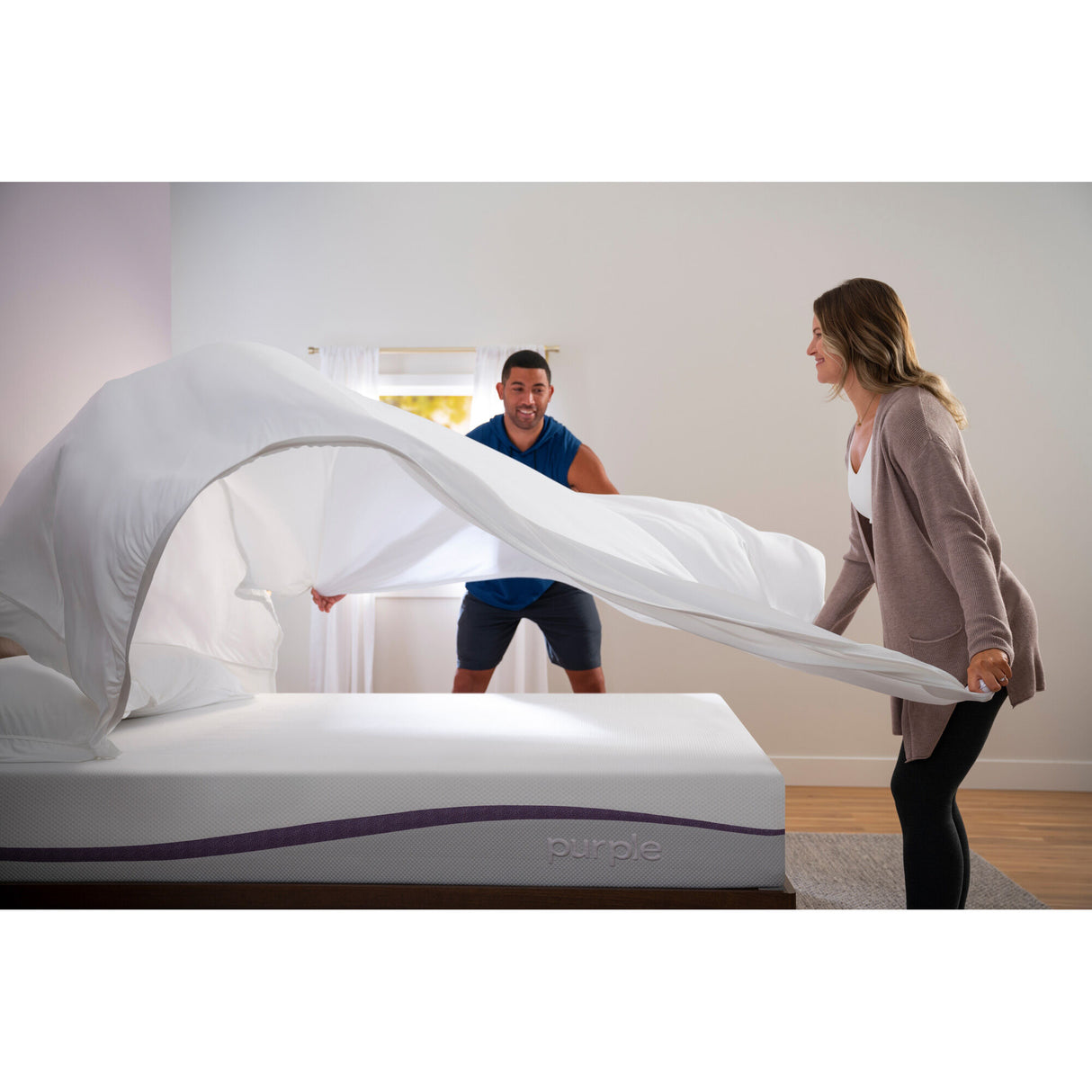 Couple putting bedding on The Purple Mattress