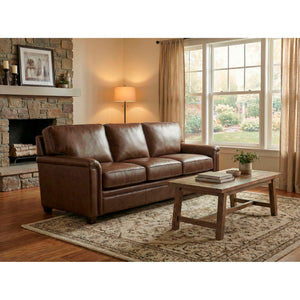 A room setting featuring Warren Chocolate Feather Blend Leather Nail Head Queen Sofa Sleeper