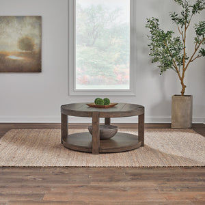 A room setting featuring Broadmore Cobblestone Brown Round Cocktail Table