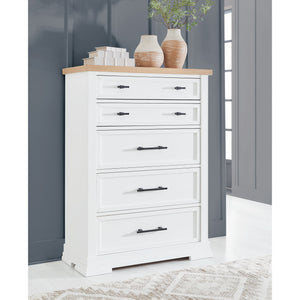 A room setting featuring Ashbryn White 5 Drawer Chest